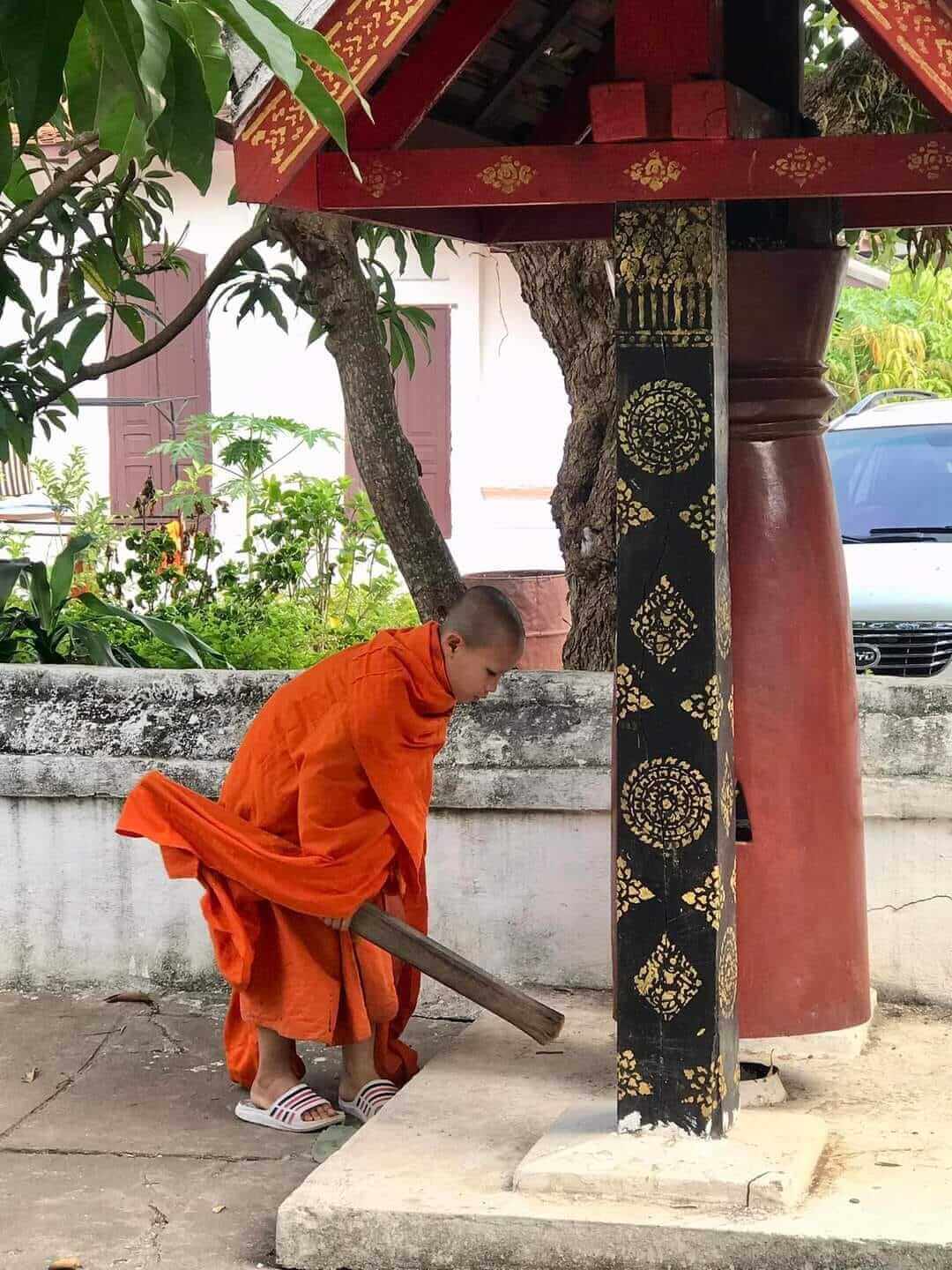 Buddhist monk beats the bells at Wat Xienthong in Luang Prabang